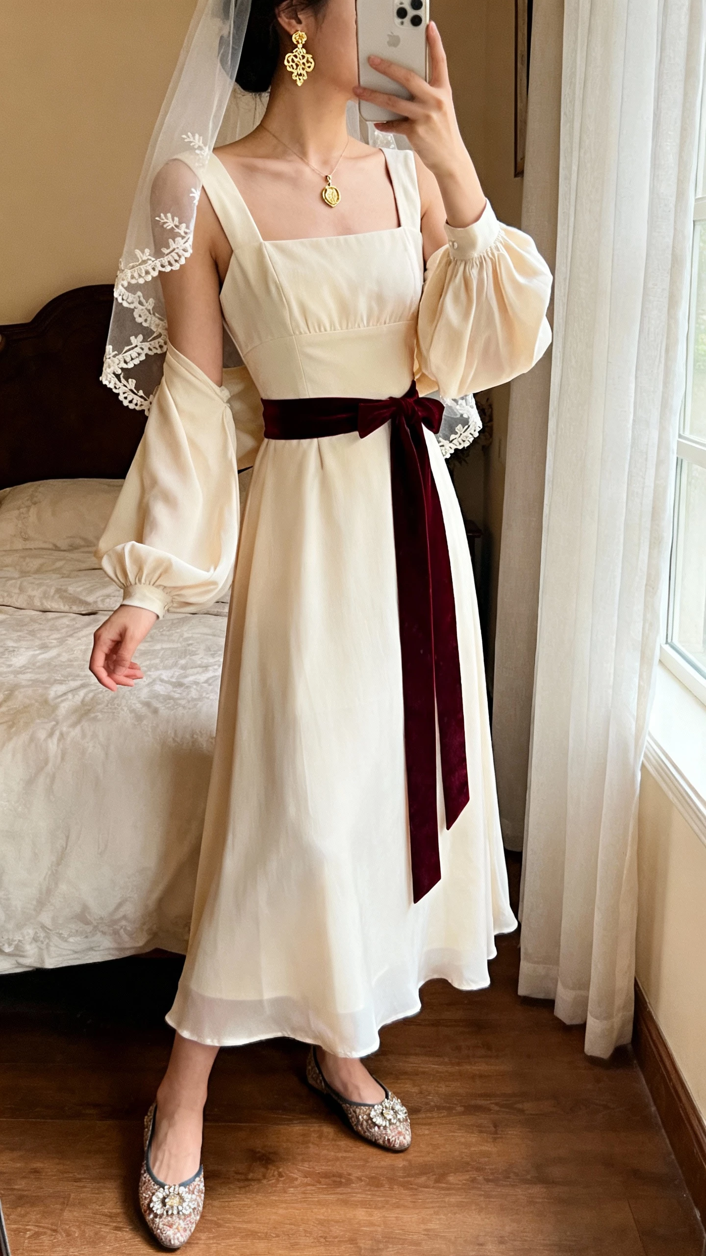 iPhone back-view selfie of a woman in a square-neck gown with structured bodice and flowing skirt, detachable poet sleeves, velvet ribbon belt, embellished flats, gold filigree earrings, dainty locket, sheer veil with embroidered edge, face not visible, vintage-style bedroom, soft window light, natural iPhone quality.