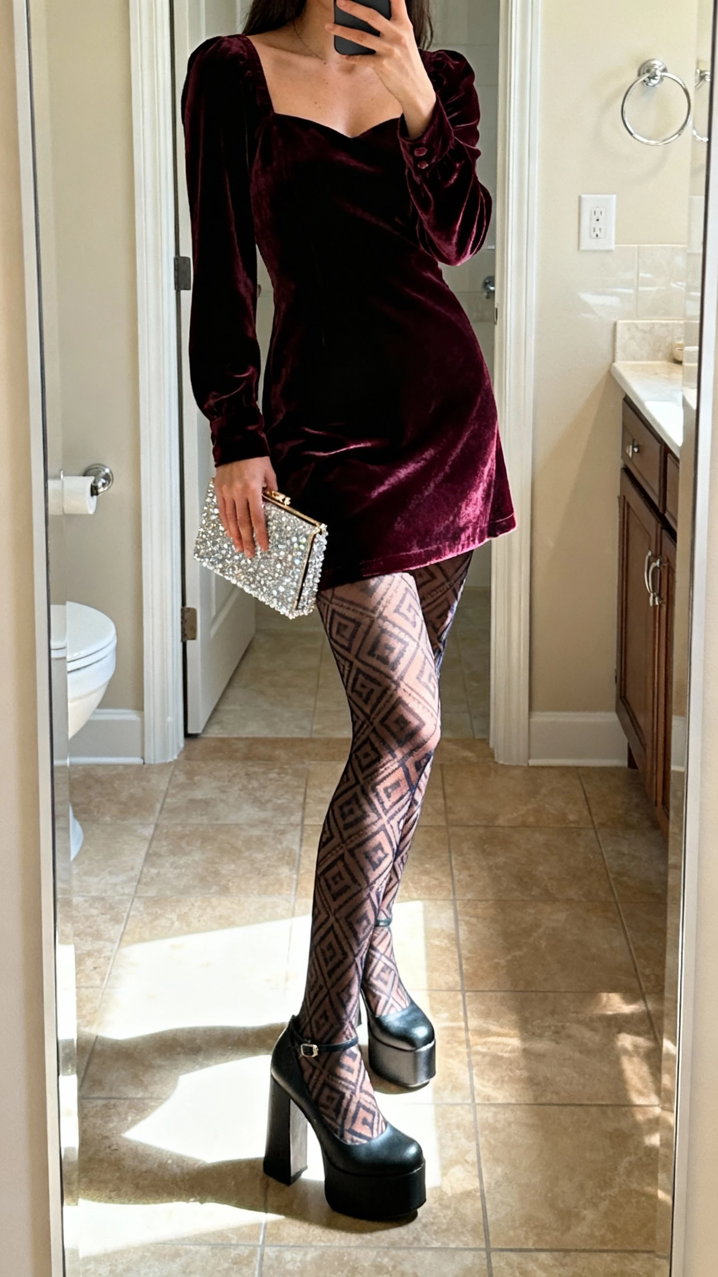 iPhone bathroom mirror selfie of a woman wearing a velvet mini dress, statement patterned tights, platform heels, sparkly clutch, face not visible, cropped at shoulders, bright indoor lighting, natural iPhone aesthetic