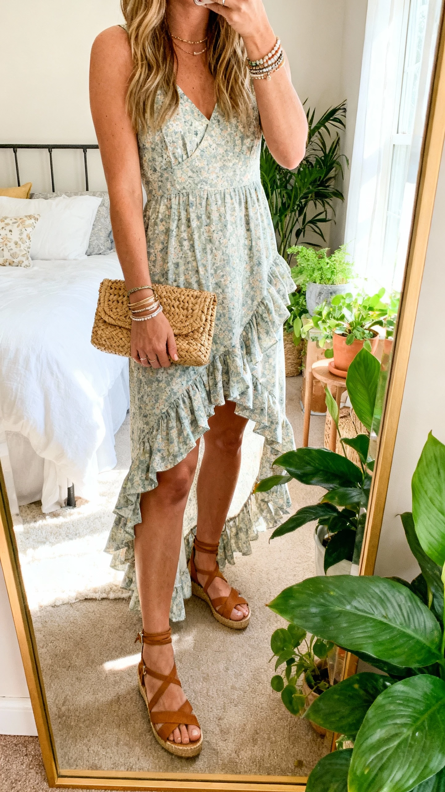 iPhone full-length mirror selfie of a woman in a ruffled high-low dress with garden-ready wedges, woven clutch, layered bracelets, face not visible, bedroom mirror with plants and bright morning light, natural iPhone aesthetic