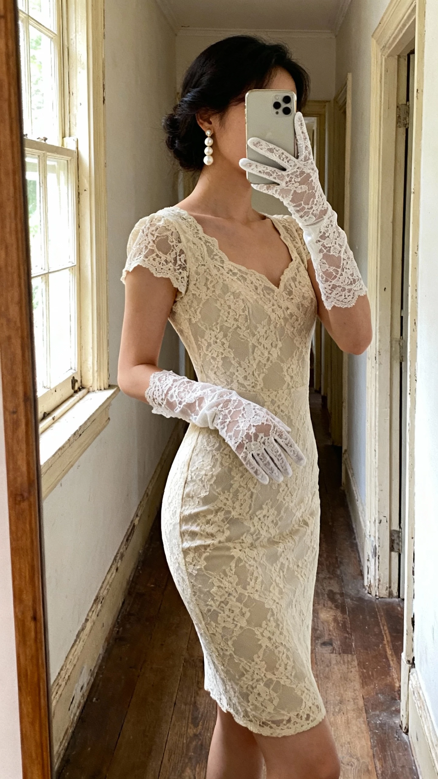 iPhone side-angle selfie of a woman wearing Chantilly lace gloves with a vintage lace sheath dress, pearl drop earrings, face not visible, hallway mirror in an old house, soft window light, natural iPhone photo quality