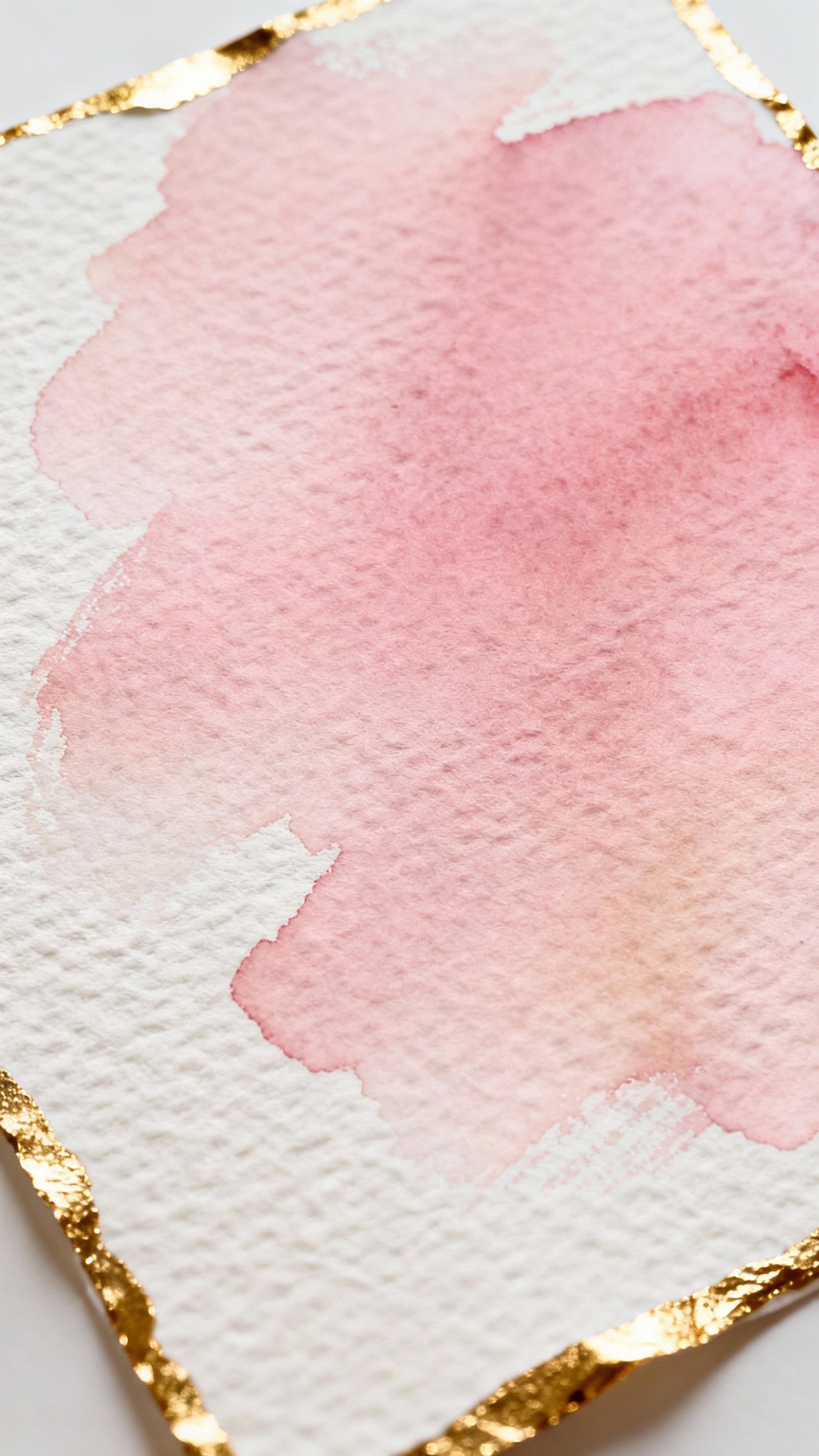 Closeup blush watercolor wash on cotton paper, gold foil edge