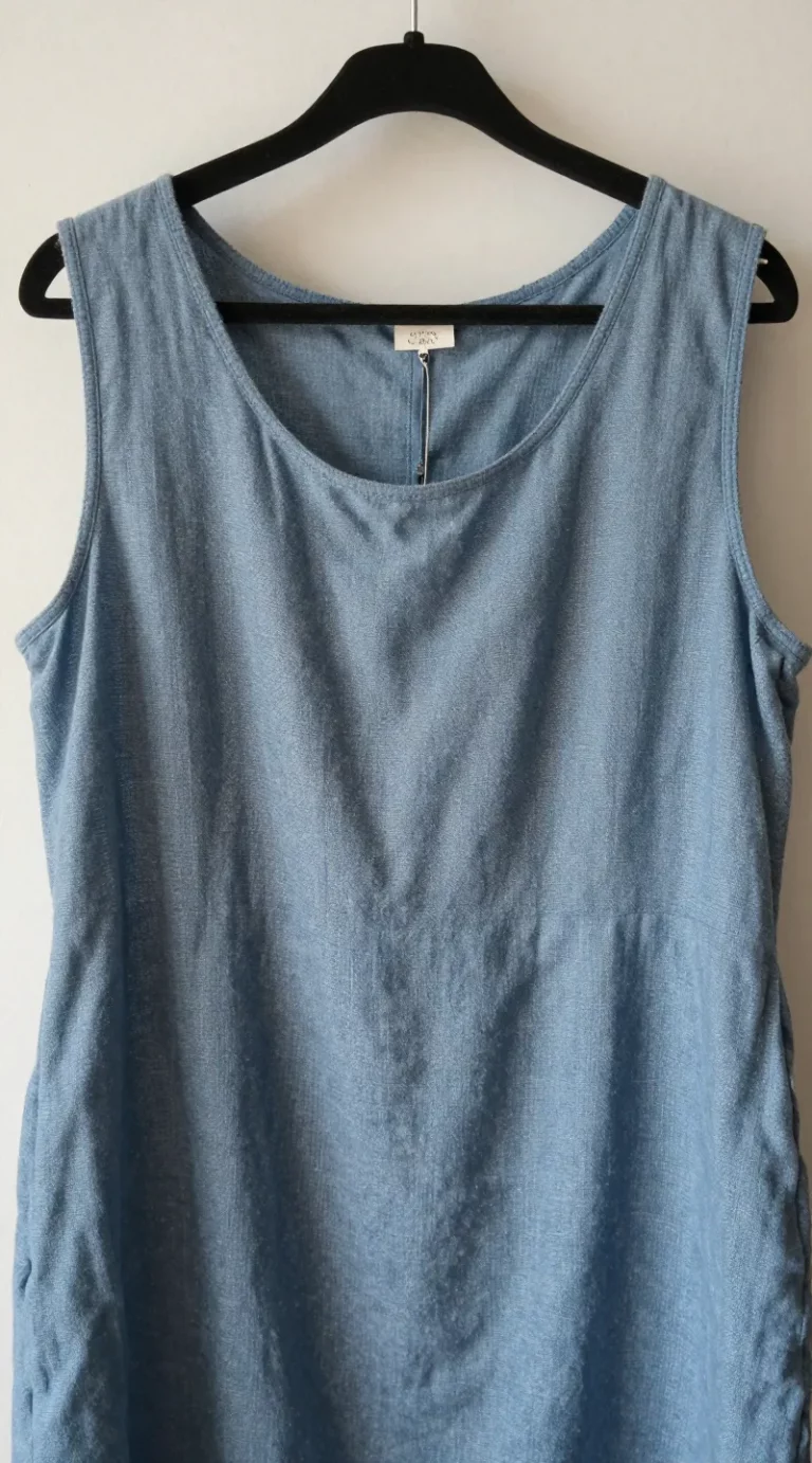 **Closeup of dusty blue linen dress on hanger**