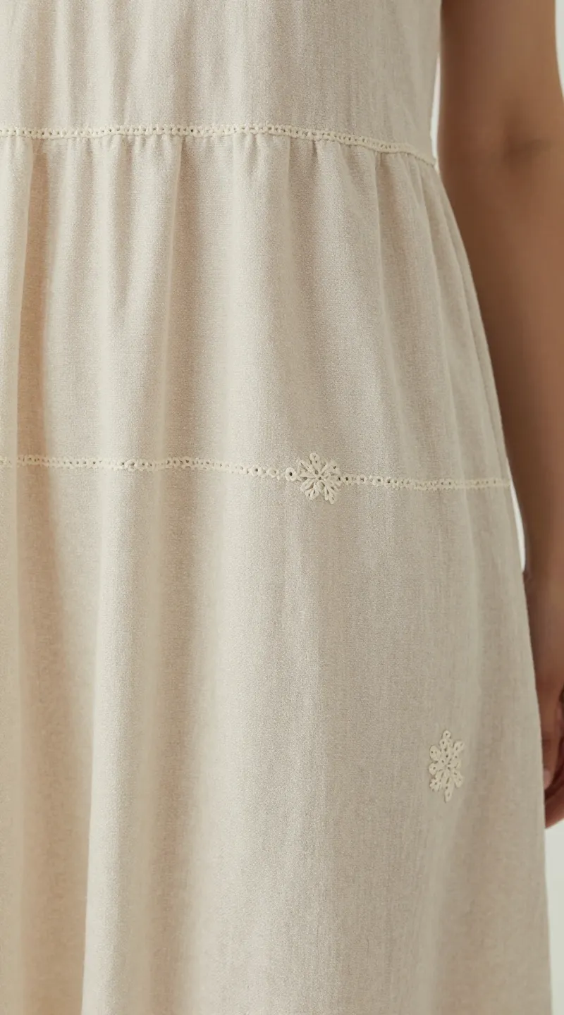 **Closeup of a linen midi dress with delicate embroidery**