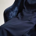 **Tailored navy midi dress draped over velvet chair**