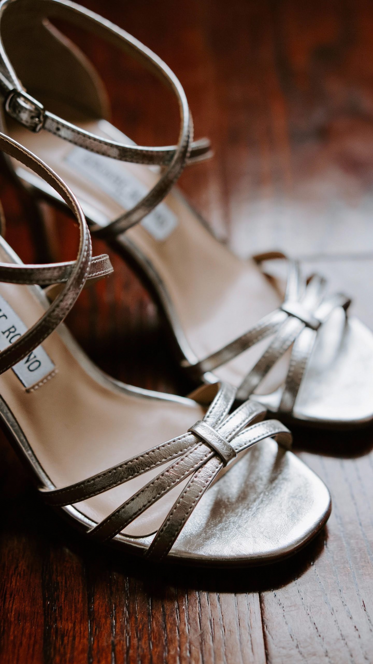 **Closeup of a pair of strappy silver heels on polished wood**  

Each prompt focuses on one elegant element appropriate for a black-tie wedding, as described in the article.