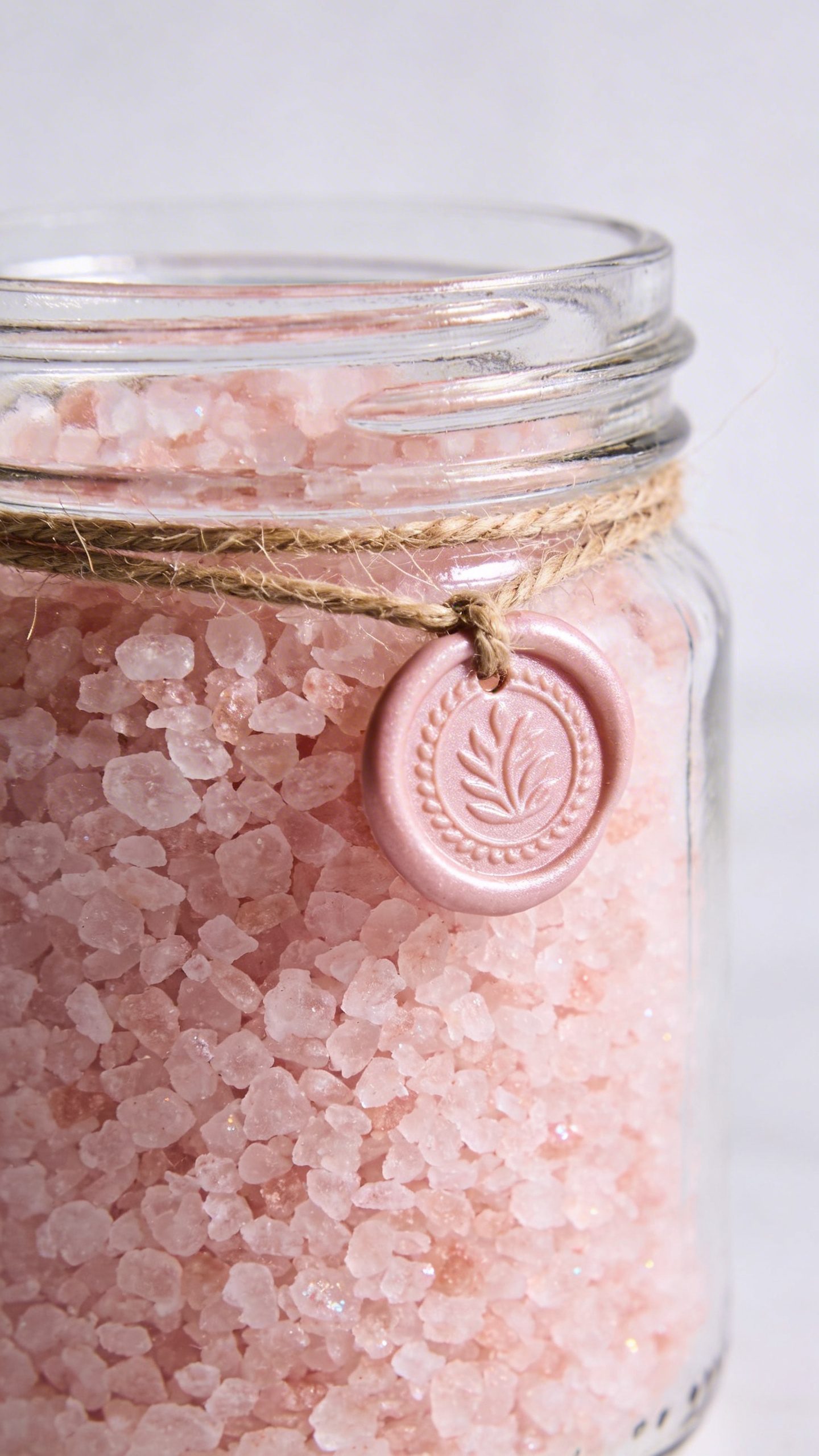 Glass jar of pink bath salts with wax-sealed twine
