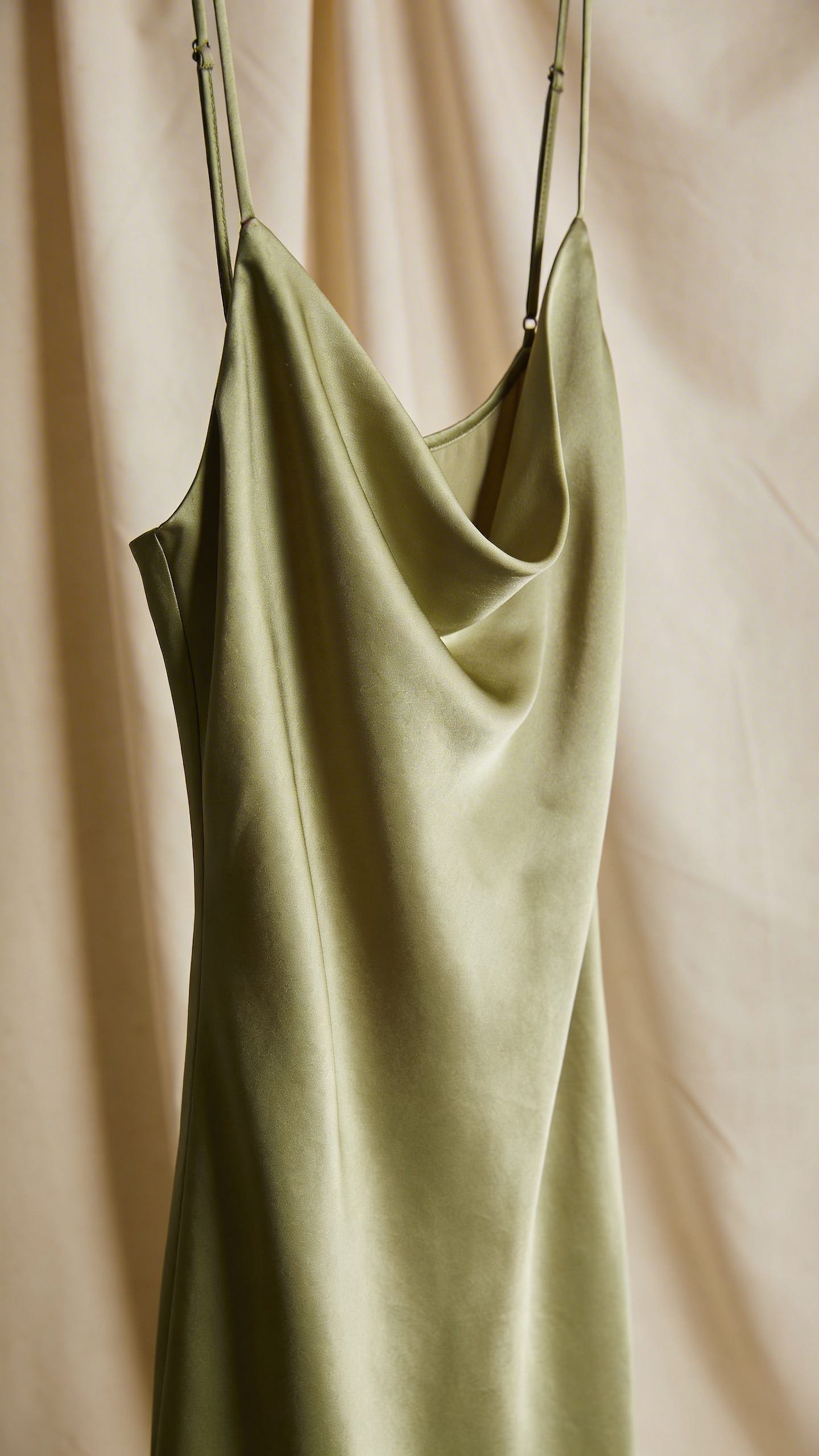 closeup pistachio satin slip dress on ecru backdrop, studio